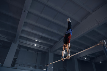 Image showing Little male gymnast training in gym, flexible and active