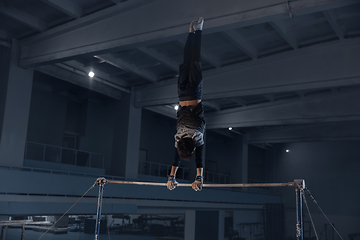 Image showing Little male gymnast training in gym, flexible and active