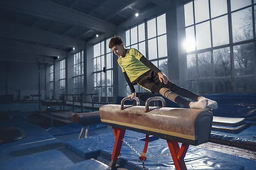 Image showing Little male gymnast training in gym, flexible and active