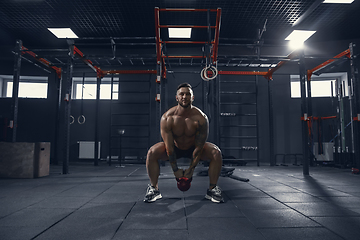 Image showing The male athlete training hard in the gym. Fitness and healthy life concept.