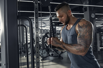 Image showing The male athlete training hard in the gym. Fitness and healthy life concept.