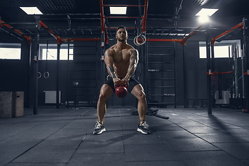 Image showing The male athlete training hard in the gym. Fitness and healthy life concept.