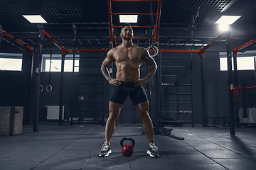 Image showing The male athlete training hard in the gym. Fitness and healthy life concept.