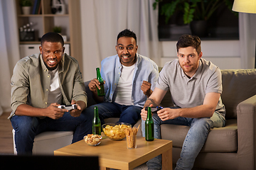 Image showing happy friends playing video games at home at night