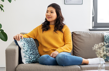 Image showing asian young woman sitting on sofa at home