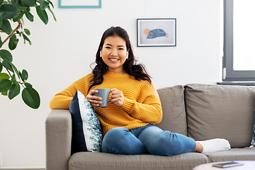 Image showing woman in earphones listening to music at home