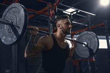 Image showing The male athlete training hard in the gym. Fitness and healthy life concept.