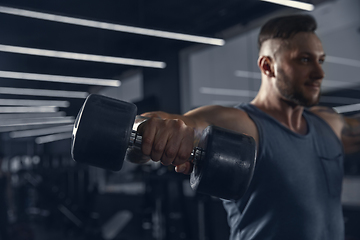 Image showing The male athlete training hard in the gym. Fitness and healthy life concept.