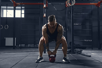 Image showing The male athlete training hard in the gym. Fitness and healthy life concept.