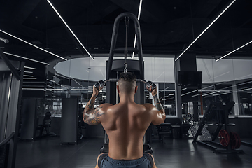 Image showing The male athlete training hard in the gym. Fitness and healthy life concept.