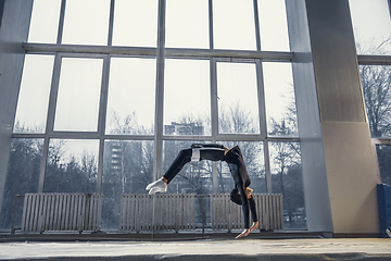 Image showing Little male gymnast training in gym, flexible and active