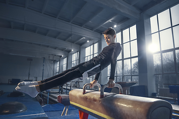 Image showing Little male gymnast training in gym, flexible and active