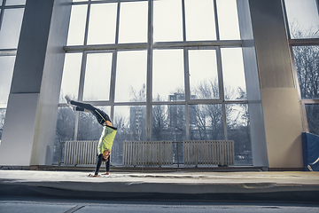 Image showing Little male gymnast training in gym, flexible and active