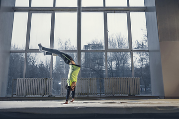 Image showing Little male gymnast training in gym, flexible and active