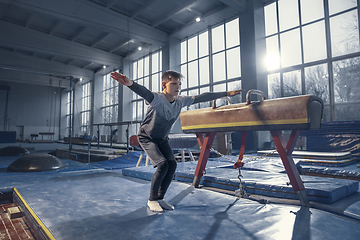 Image showing Little male gymnast training in gym, flexible and active