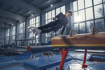 Image showing Little male gymnast training in gym, flexible and active