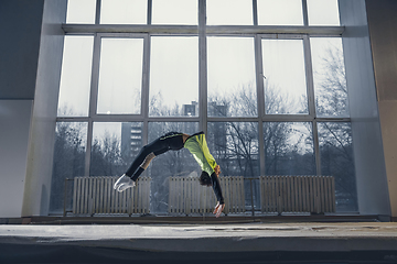 Image showing Little male gymnast training in gym, flexible and active