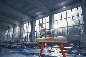 Image showing Little male gymnast training in gym, flexible and active