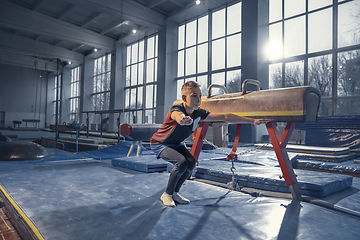 Image showing Little male gymnast training in gym, flexible and active