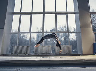 Image showing Little male gymnast training in gym, flexible and active