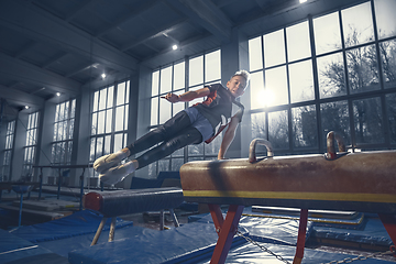 Image showing Little male gymnast training in gym, flexible and active