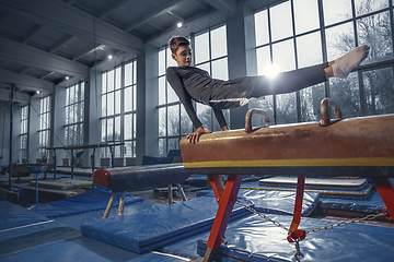 Image showing Little male gymnast training in gym, flexible and active