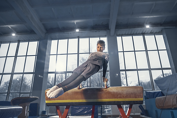 Image showing Little male gymnast training in gym, flexible and active