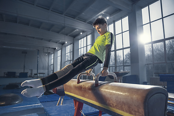 Image showing Little male gymnast training in gym, flexible and active