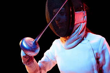 Image showing Teen girl in fencing costume with sword in hand isolated on black background