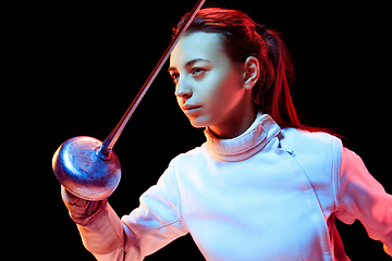 Image showing Teen girl in fencing costume with sword in hand isolated on black background