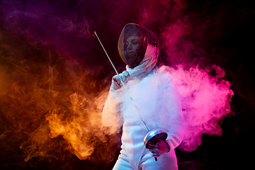 Image showing Teen girl in fencing costume with sword in hand isolated on black background