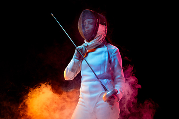 Image showing Teen girl in fencing costume with sword in hand isolated on black background