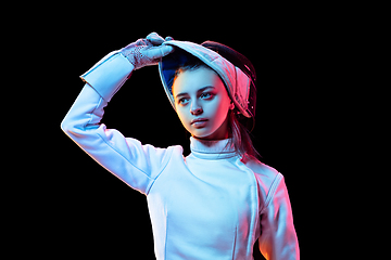 Image showing Teen girl in fencing costume with sword in hand isolated on black background