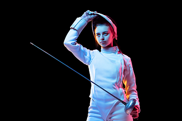 Image showing Teen girl in fencing costume with sword in hand isolated on black background