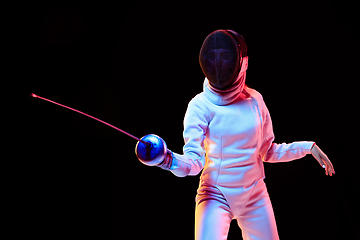 Image showing Teen girl in fencing costume with sword in hand isolated on black background