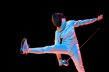 Image showing Teen girl in fencing costume with sword in hand isolated on black background