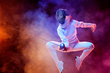 Image showing Teen girl in fencing costume with sword in hand isolated on black background