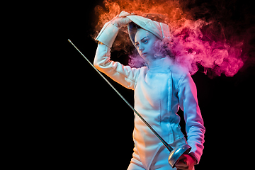 Image showing Teen girl in fencing costume with sword in hand isolated on black background