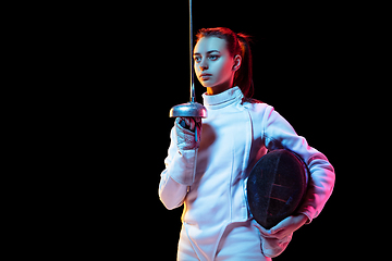 Image showing Teen girl in fencing costume with sword in hand isolated on black background