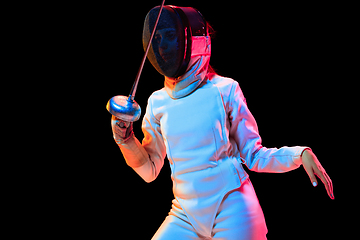 Image showing Teen girl in fencing costume with sword in hand isolated on black background