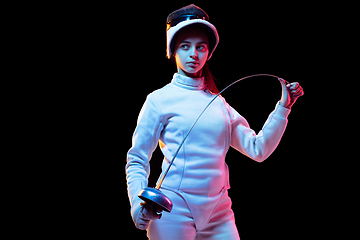 Image showing Teen girl in fencing costume with sword in hand isolated on black background