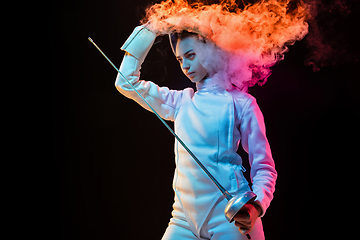 Image showing Teen girl in fencing costume with sword in hand isolated on black background