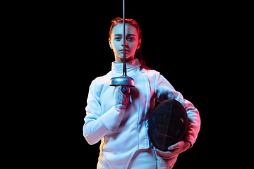 Image showing Teen girl in fencing costume with sword in hand isolated on black background