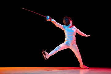 Image showing Teen girl in fencing costume with sword in hand isolated on black background