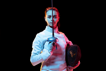 Image showing Teen girl in fencing costume with sword in hand isolated on black background