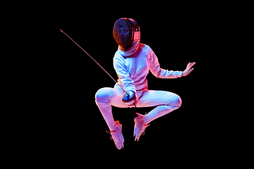 Image showing Teen girl in fencing costume with sword in hand isolated on black background