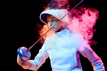 Image showing Teen girl in fencing costume with sword in hand isolated on black background