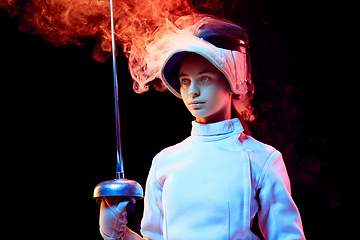 Image showing Teen girl in fencing costume with sword in hand isolated on black background