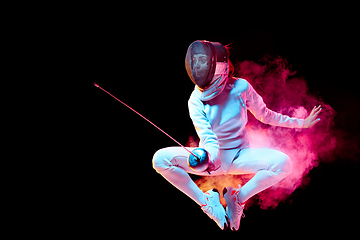 Image showing Teen girl in fencing costume with sword in hand isolated on black background