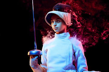 Image showing Teen girl in fencing costume with sword in hand isolated on black background